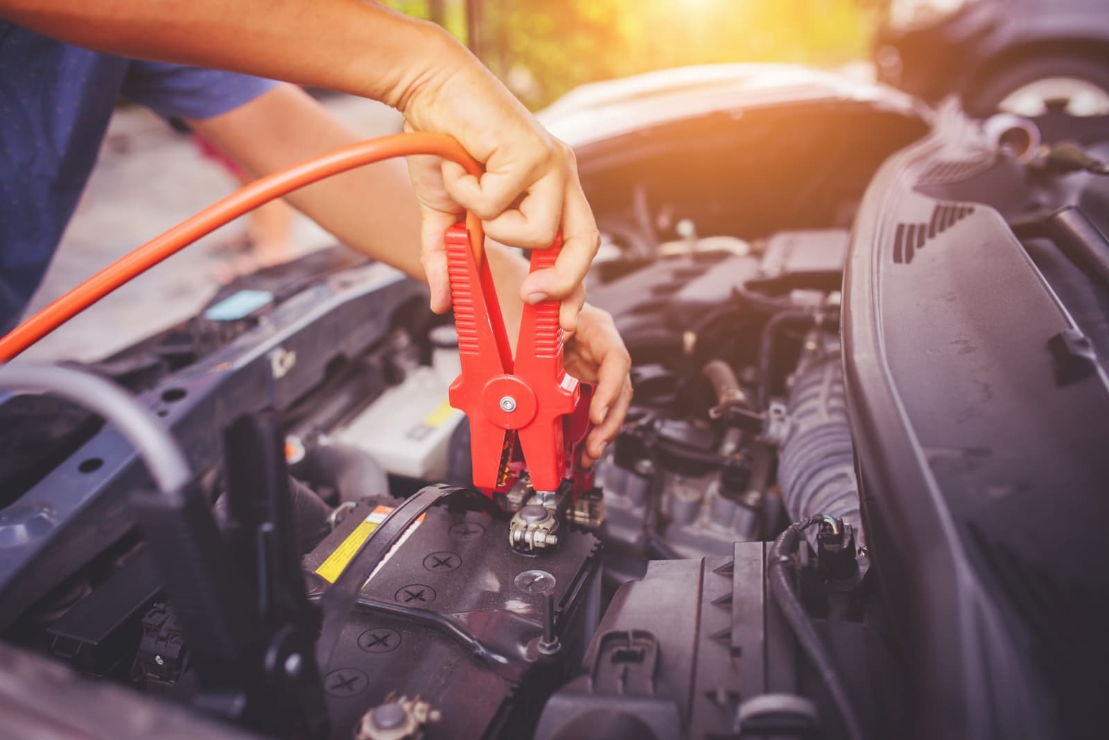 Monteur geeft starthulp met startkabels op een lege auto-accu